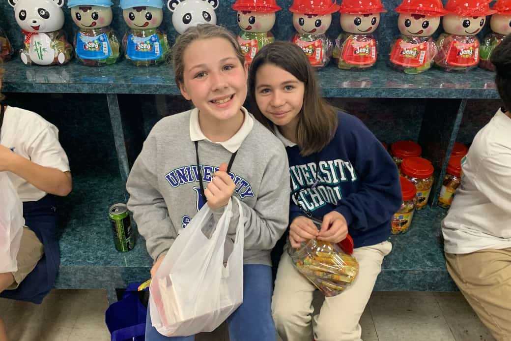 Two young USL students smile while holding goodies