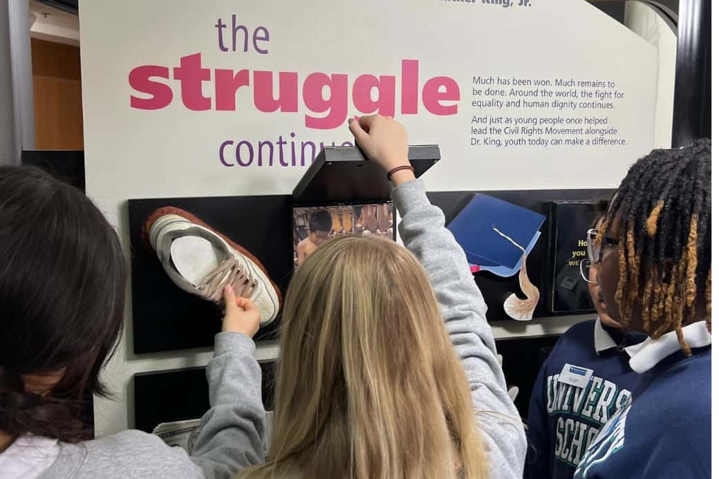 USL students touch and examine items on exhibit at a museum